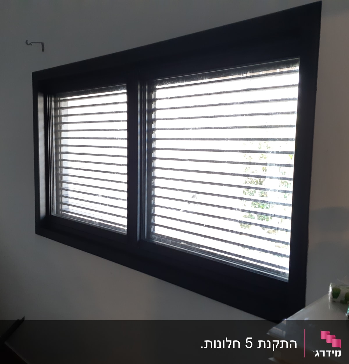 חלון עם תריסי אלומיניום סגורים